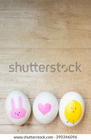 Easter eggs on wooden background. Painting with cute cartoon , heart , bunny and chicken.