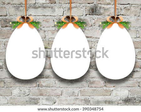 Close-up of three hanged blank decorated Easter eggs with ribbon against weathered brick wall background