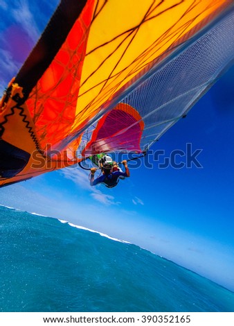 Self photo of windsurfing front loop flight over stormy sea