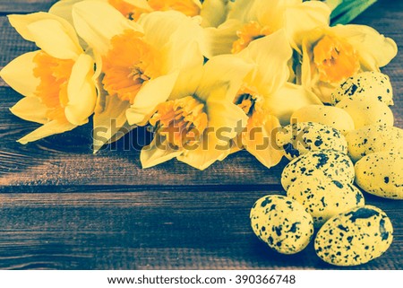 Beautiful daffodils flowers and easter eggs on wood useful as easter greeting card, vintage photo with copy space