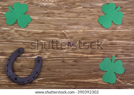 Fabric green clover leaves with horseshoe on wooden background. 