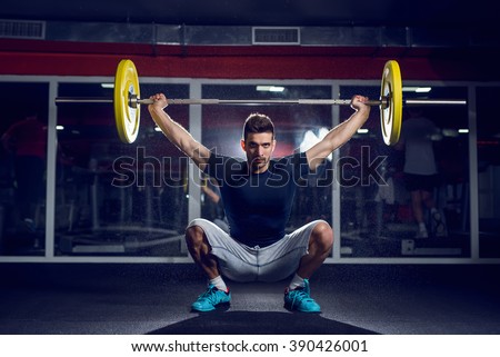 Handsome weightlifter preparing for training. Shallow depth of field. Royalty-Free Stock Photo #390426001