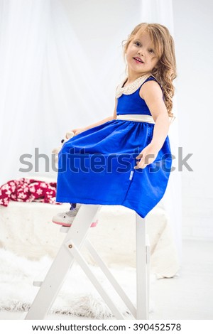Little girl in a beautiful blue dress playing