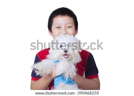 Picture of happy little boy holding a maltese dog in the studio, isolated on white background