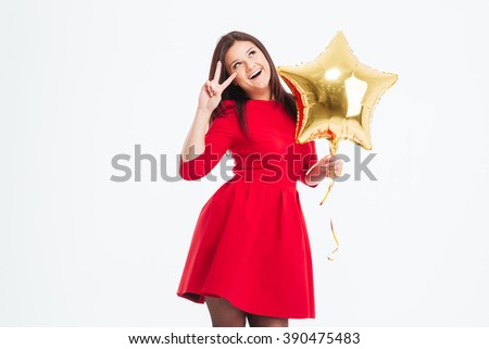 Cheerful woman in red dress holding balloon and showing two fingers sign isolated on a white background