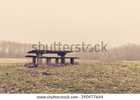 Bench in a park in the mist at autumn
