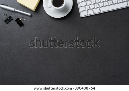High angle view of office black desk with copy space. Table with keyboard, computer, coffee cup and supplies. Top view of blackboard office desk. Businessman or student desk. Royalty-Free Stock Photo #390488764