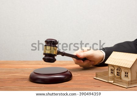 Auction, Real Estate concept. Hand with judge gavel and house model