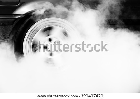Drag car burning tire for warm up tire before competition, Drag car wheel spinning wheel and smoking. Royalty-Free Stock Photo #390497470