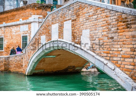Classical picture of the venetian canals with gondola across the canal