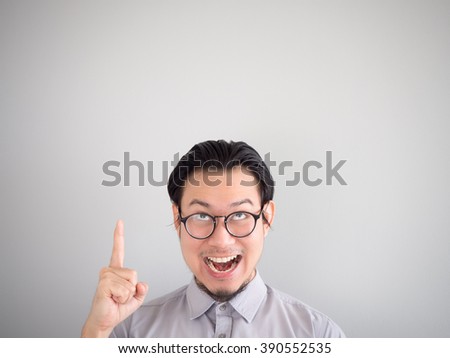 Very happy Asian business man pointing on empty space.
