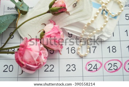 Woman hygiene protection, close-up.menstruation calendar with cotton tampons,pink rose, a symbol of femininity.female pearl necklace.feminine pads