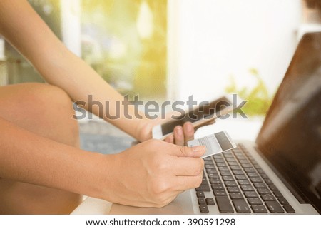 Woman hold Credit Card and smart phone on laptop for online shopping.