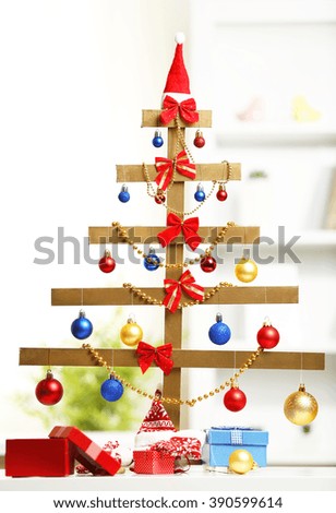 A handmade Christmas tree and presents on the table, in the room