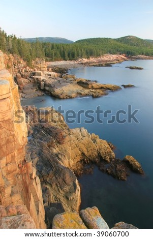 Otter Cliffs and calm shoreline illuminated by the early morning sun in Acadia National Park, Maine
