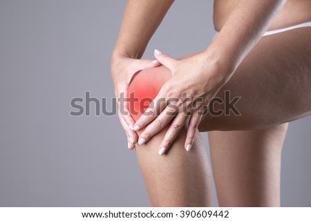 Pain in knee. Ache in human body on a gray background with red dot