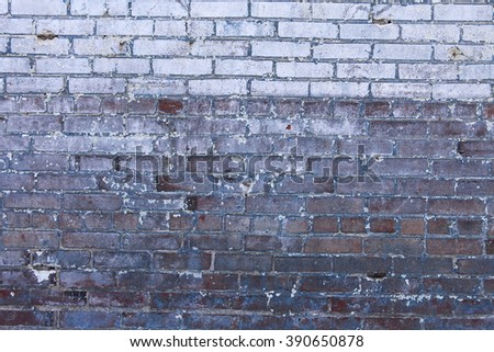 Brick wall with blue and white paint peeling