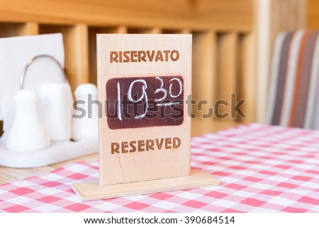 Wooden board with table reservation information in restaurant. Table reserved for dinner in cafe