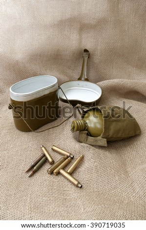 Army water bottle and cartridges on the background fabric.