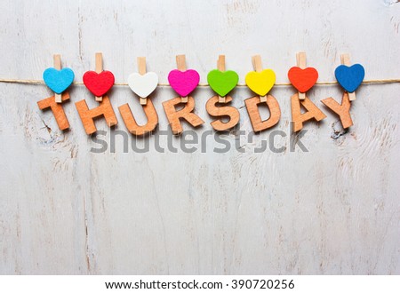 word Thursday from wooden letters with colored clothespins on a white wooden background Royalty-Free Stock Photo #390720256