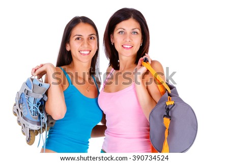 Closeup Portrait of two hugging women with roller skates and sports bag in hand, isolated on white