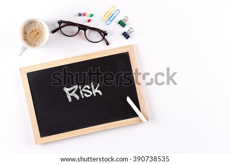 Risk word on chalkboard with coffee cup and eyeglasses, view from above