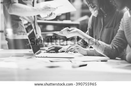 Team succes. Photo young talent managers crew working with new startup project in modern loft. Generic design notebook on wood table. Horizontal, film effect, black and white Royalty-Free Stock Photo #390755965