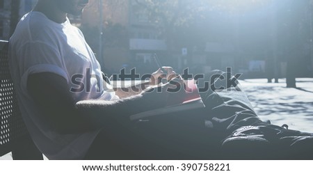 Photo man sitting student campus and texting message notepad. Studying at the University, working project, preparing exam. Using book, generic design laptop. Wide mock up, sunlights