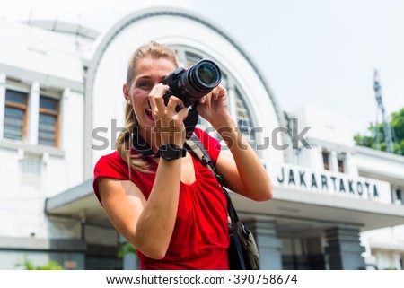 Woman photographing train station sightseeing with camera in Jakarta, Indonesia