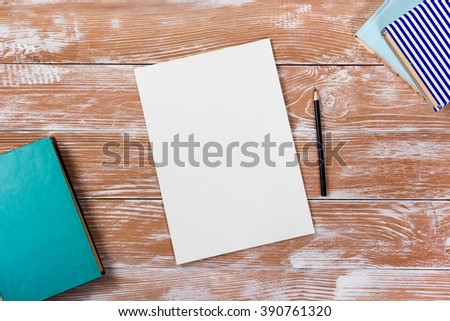 Office table desk with supplies, white blank note pad, cup, pen, pc, crumpled paper, flower on wooden background. Top view