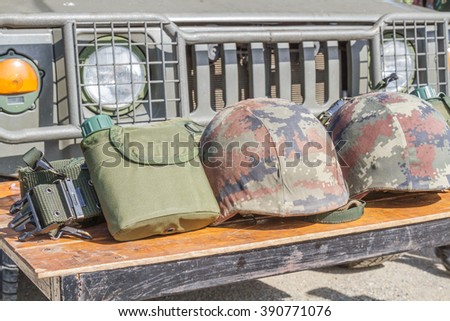 Helmet military and Military flask on wooden table.