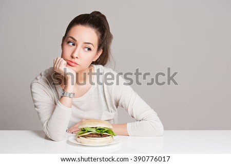 Portrait of a young brunette beauty offering nutrition choices.