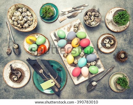 Easter decoration. Festive table place setting with colored eggs. Vintage style toned picture