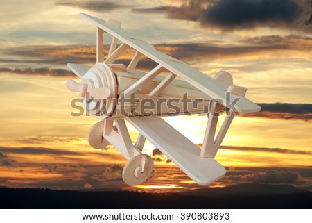 Wooden toy airplane flying in summer  sky.Concept of imagination.