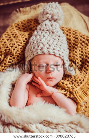 Newborn in hat on the blankets
