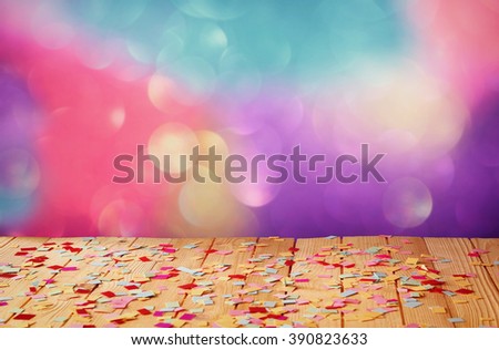 wooden table with colorful confetti. vintage filtered image
