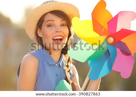 Young happy funny (vintage) dressed woman with colorful weather vane,looking like flower
 Picture ideal for illustating woman magazines.