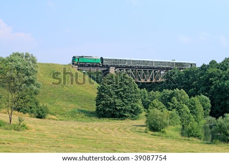 Passenger train passing through the big steel bridge