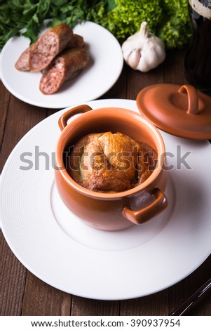 Sausage Yorkshire pudding in the baking pot on wooden background close up. English Toad in the Hole, a traditional British dish.