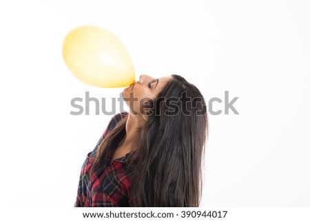 young beautiful woman holding balloon with his mouth
