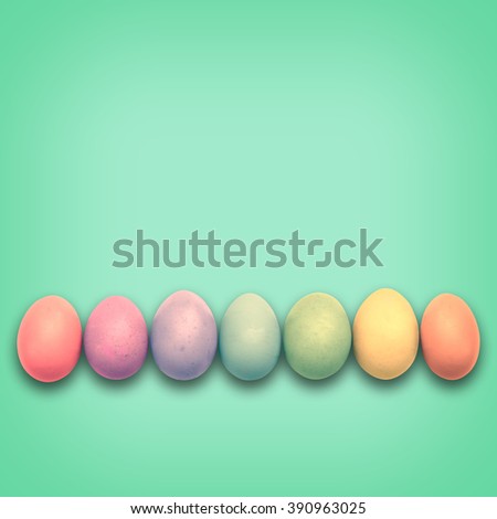 Pastel Easter eggs aligned, green background