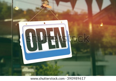 Open sign hanging on glass door in cafe. Retro color style.