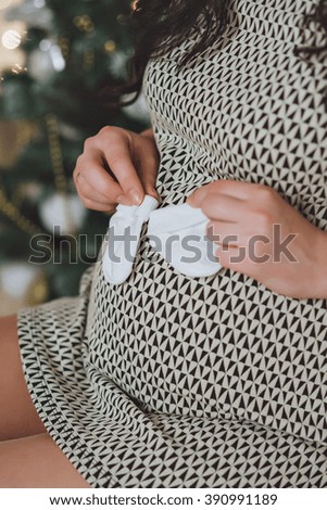 pregnant woman put booties to my stomach. WHITE puts booties