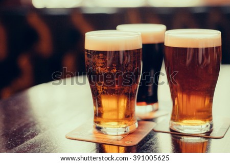Glasses of light and dark beer on a pub background. Royalty-Free Stock Photo #391005625
