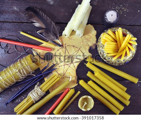Background with assorted candles, quill and paper with pentagram, top view.  Black magic ritual. Scary still life with occult and esoteric symbols. Halloween or divination rite