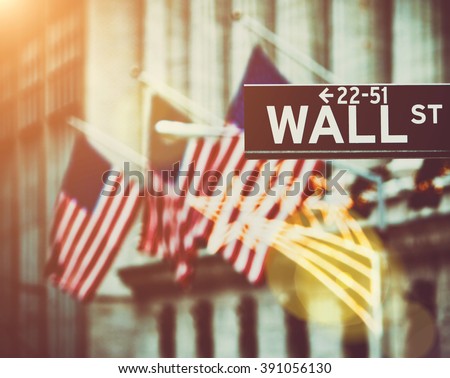 Wall street sign in New York with New York Stock Exchange background  Royalty-Free Stock Photo #391056130
