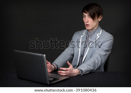 Businessman surprised looks on the computer, studio picture