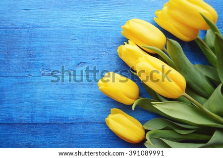 bouquet of yellow tulips on a wooden background