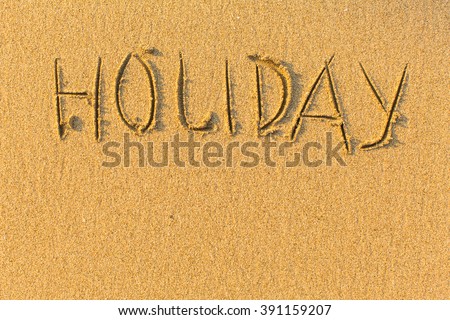 Holiday - word drawn on the sand beach.