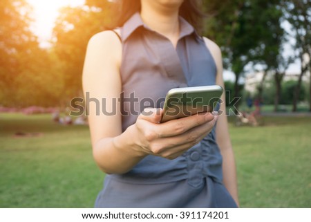 Focus hand of Young woman touching smartphone - Sunset filter effect